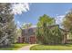 Charming home featuring a landscaped front yard with mature trees and a brick pathway at 3825 S Peach Way, Denver, CO 80237