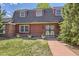 Traditional home exterior showing a red brick walkway leading to an ornate wrought iron front door at 3825 S Peach Way, Denver, CO 80237