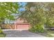 Exterior view of two-car garage with pink doors and brick and siding exterior at 3825 S Peach Way, Denver, CO 80237