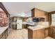 Traditional kitchen with wood cabinetry, tile countertops, and modern appliances at 3825 S Peach Way, Denver, CO 80237