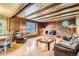 Inviting living room with brick fireplace, wood-paneled walls and comfortable leather furniture at 3825 S Peach Way, Denver, CO 80237