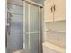 A blue tiled shower stall with a sliding glass door and chrome fixtures at 3825 S Peach Way, Denver, CO 80237