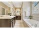 Bathroom with double vanities, soaking tub, and modern finishes at 19382 Dunraven St, Parker, CO 80134