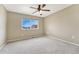 Empty bedroom with neutral walls, carpeted floors, and large window with natural light at 19382 Dunraven St, Parker, CO 80134