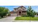 Charming two-story home with a brick facade, well-maintained lawn, and attached garage at 19382 Dunraven St, Parker, CO 80134