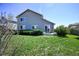A sunny backyard with green grass, plants, and a patio against the back of the house at 11191 W Crestline Dr, Littleton, CO 80127
