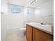 This bathroom offers ample light with a window above the bathtub and a vanity with a white countertop at 11191 W Crestline Dr, Littleton, CO 80127