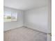 Bright bedroom with neutral carpet, white walls and a window overlooking the front yard at 11191 W Crestline Dr, Littleton, CO 80127