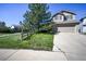 Two-story home featuring a two-car garage, mature tree, and a spacious front lawn at 11191 W Crestline Dr, Littleton, CO 80127