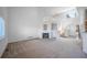 Spacious living room featuring a cozy fireplace, open staircase, and plenty of natural light at 11191 W Crestline Dr, Littleton, CO 80127