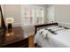 Cozy bedroom with wooden floors, white plantation shutters, and a comfortable bed with a decorative blanket at 569 S Race St, Denver, CO 80209