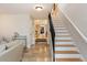 Inviting hallway with tile flooring, stairway with black metal railing, and a view into adjoining rooms at 569 S Race St, Denver, CO 80209