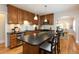 Bright kitchen with wood cabinets, black countertops and an island with seating for casual dining at 569 S Race St, Denver, CO 80209