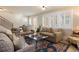Bright living room featuring large windows with shutters, comfortable couches, and a stylish rug at 569 S Race St, Denver, CO 80209