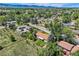 Wide aerial showing the property's landscape with mature trees surrounding neighborhood, under a partly cloudy sky at 11310 W 46Th Ave, Wheat Ridge, CO 80033