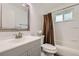 Bathroom featuring modern vanity and mirror, toilet and shower with neutral colored shower curtain at 11310 W 46Th Ave, Wheat Ridge, CO 80033