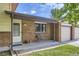 Cozy covered porch with a chair, potted plant, brick accents, and direct access to the garage at 11310 W 46Th Ave, Wheat Ridge, CO 80033