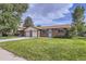 Well-maintained brick home with a two-car garage and a green lawn, set under a partly cloudy sky at 11310 W 46Th Ave, Wheat Ridge, CO 80033