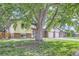 Charming two-story home featuring brick accents, a well-maintained lawn, and a large tree in the front yard at 11310 W 46Th Ave, Wheat Ridge, CO 80033