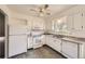 Well-lit kitchen featuring white cabinets, modern appliances, granite countertops, and an adjacent dining area at 11310 W 46Th Ave, Wheat Ridge, CO 80033