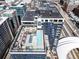 Aerial view of the building with rooftop pool, seating, and downtown skyline at 1750 Wewatta St # 1230, Denver, CO 80202