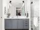 Elegant bathroom featuring a vanity with gray cabinets, marble tile, and a large mirror at 1750 Wewatta St # 1230, Denver, CO 80202