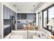 Stylish kitchen boasts gray cabinetry, stainless steel appliances, and an eat-in area with city views at 1750 Wewatta St # 1230, Denver, CO 80202