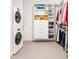 Well-organized laundry room featuring stacked washer/dryer and built-in storage shelves at 1750 Wewatta St # 1230, Denver, CO 80202