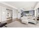 Open-concept living space flows to a modern kitchen and bedroom with comfortable sofa and ottoman at 1750 Wewatta St # 1230, Denver, CO 80202