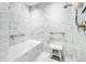 Modern shower and tub with white marble tile, a glass door, and a built-in bench at 1750 Wewatta St # 1230, Denver, CO 80202