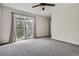 Bedroom featuring gray carpet, white walls, and sliding glass doors to outdoor balcony at 9605 E Kansas Cir # 53, Denver, CO 80247