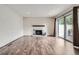 Spacious living room with hardwood flooring, brick fireplace and access to outdoor deck at 9605 E Kansas Cir # 53, Denver, CO 80247