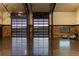 Modern gym interior with roll-up doors offering mountain views and rustic wood accents at 6502 & 6200 Kiva Ridge Dr, Berthoud, CO 80513
