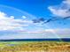 Scenic view featuring a rainbow over a lush landscape of rolling hills, lakes, and sky at 6502 & 6200 Kiva Ridge Dr, Berthoud, CO 80513