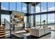 Sun-drenched living room with floor-to-ceiling windows, modern fireplace, and open staircase at 6502 & 6200 Kiva Ridge Dr, Berthoud, CO 80513