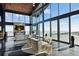 Bright living area with fireplace, sleek furniture, and floor-to-ceiling windows showcasing breathtaking views at 6502 & 6200 Kiva Ridge Dr, Berthoud, CO 80513