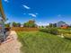 Beautiful backyard with a manicured lawn, mature landscaping, and privacy fencing at 448 Bonanza Dr, Erie, CO 80516