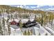 Aerial view of a home nestled amongst the trees on a snow covered mountain side at 1279 Estates Dr, Breckenridge, CO 80424