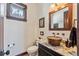 Charming powder room with copper sink, granite countertop, wood mirror, and decorative fixtures at 1279 Estates Dr, Breckenridge, CO 80424