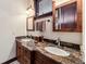 Stylish bathroom with a granite countertop, double sinks, wood cabinetry, and modern fixtures, providing a sophisticated space at 1279 Estates Dr, Breckenridge, CO 80424