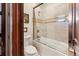 Clean bathroom featuring a bathtub with glass shower door, a toilet, and neutral tile, offering a fresh and functional space at 1279 Estates Dr, Breckenridge, CO 80424