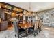 Elegant dining area with wood dining table, stone accents, antler chandelier, and kitchen access at 1279 Estates Dr, Breckenridge, CO 80424