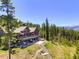 Beautiful exterior view featuring a large deck, a hot tub, and a stone patio at 1279 Estates Dr, Breckenridge, CO 80424