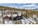 Beautiful mountain home nestled in the trees covered in snow, showcasing a large deck at 1279 Estates Dr, Breckenridge, CO 80424