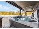 Relaxing hot tub on a covered patio with scenic views of snow-covered trees and a blue sky, perfect for outdoor enjoyment at 1279 Estates Dr, Breckenridge, CO 80424