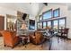 Cozy living room boasts stone fireplace, vaulted ceiling, and large windows with picturesque views at 1279 Estates Dr, Breckenridge, CO 80424