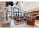 Bright living room with stone fireplace, leather sofas, and mountain views through large windows at 1279 Estates Dr, Breckenridge, CO 80424