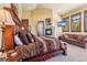 This primary bedroom features an upholstered headboard and stone fireplace, accompanied by a sitting area at 1279 Estates Dr, Breckenridge, CO 80424