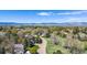 Aerial view capturing the home nestled among lush trees and well-manicured lawns with mountain views at 7999 Centrebridge Dr, Niwot, CO 80503