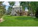 Lush backyard with a well-kept lawn, large trees, a wooden deck, and ample space for outdoor activities at 7999 Centrebridge Dr, Niwot, CO 80503